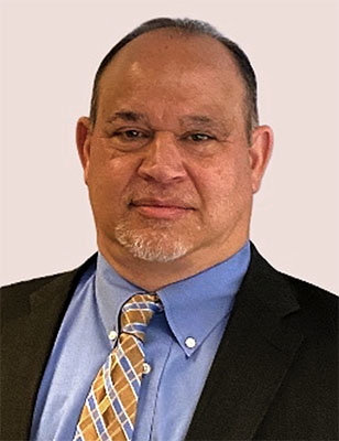 A photo of David A. Bergantino in a dark suit with blue shirt and patterned tie